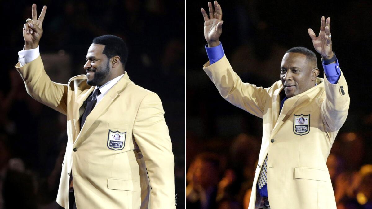 Running back Jerome Bettis, left, and wide receiver Tim Brown their gold jackets during a Hall of Fame dinner on Friday in Canton, Ohio.