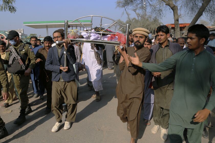Relatives carry the body of Mushtaq Ahmed, 41, who was killed when an enraged mob stoned him to death for allegedly desecrating the Quran, in Tulamba, a remote village in the district of Khanewal in eastern Pakistan, Sunday, Feb. 13, 2022. Mob attacks on people accused of blasphemy are common in this conservative Islamic nation where blasphemy is punishable by death. (AP Photo/Asim Tanveer)