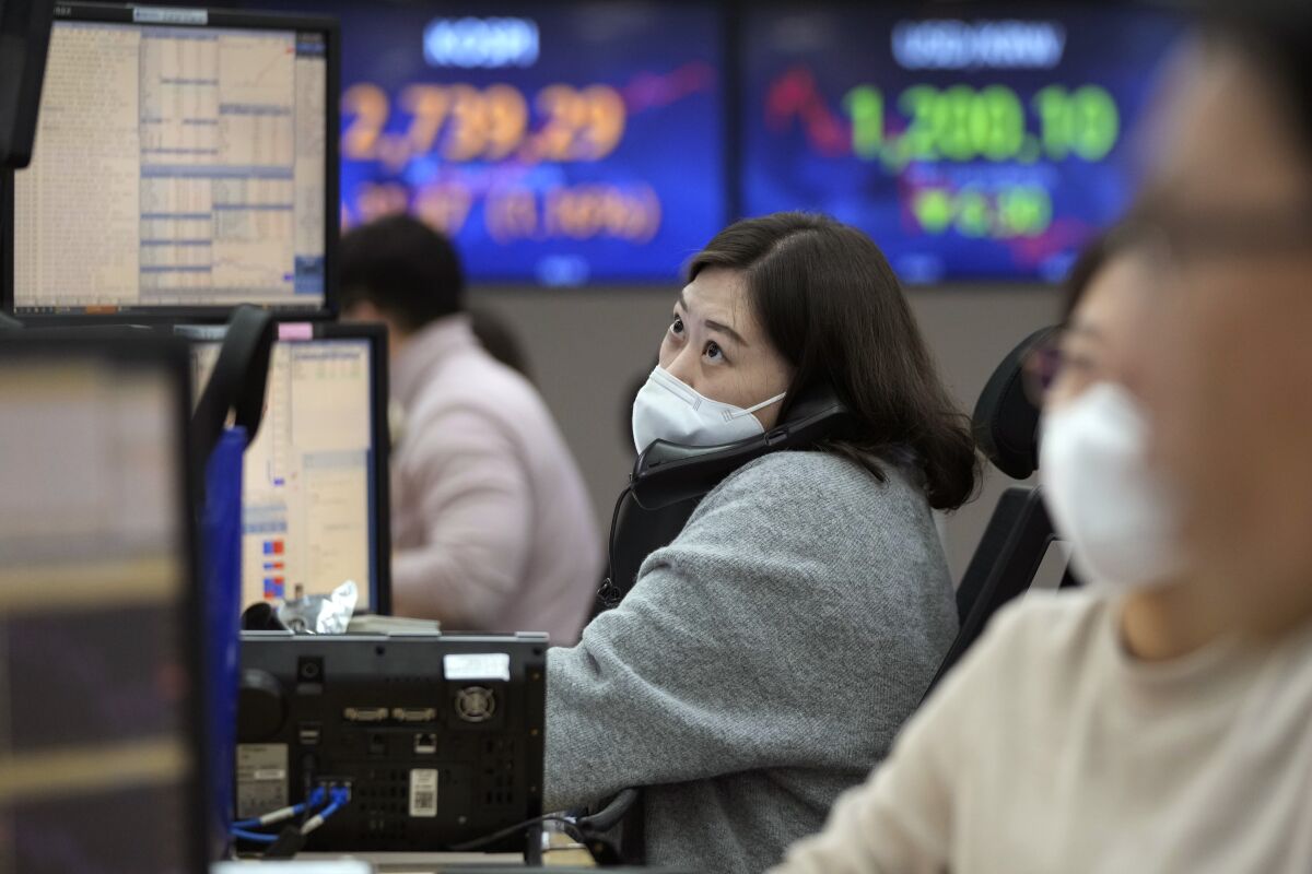 A currency trader watches monitors at the foreign exchange dealing room of the KEB Hana Bank headquarters in Seoul, South Korea, Friday, Feb. 4, 2022. Asian shares were mixed Friday after a historic plunge in the stock price of Facebook’s parent company helped yank other tech stocks lower on Wall Street. (AP Photo/Ahn Young-joon)