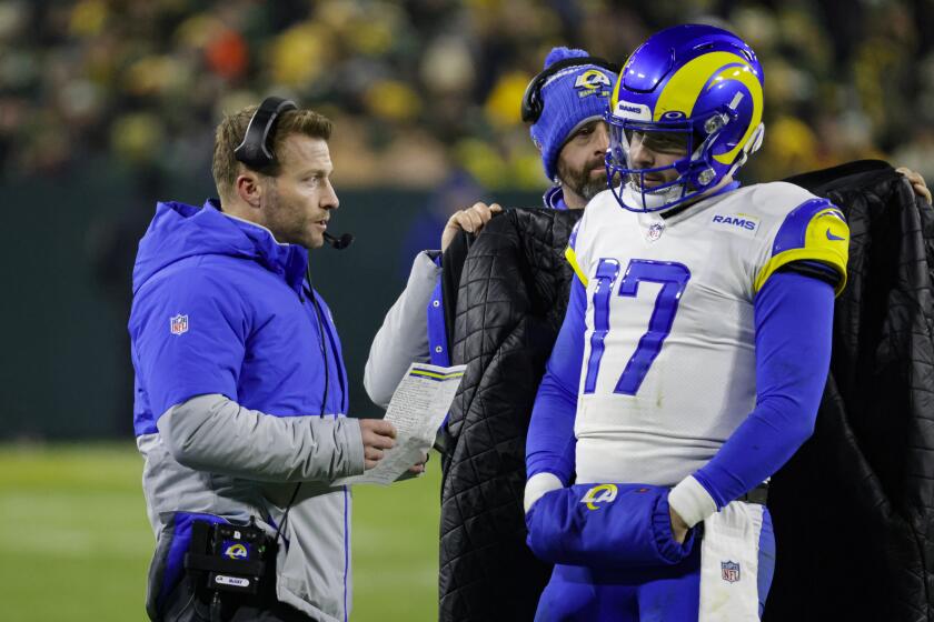 Los Angeles Rams head coach Sean McVay talks with quarterback Baker Mayfield (17) in the second half of an NFL football game against the Green Bay Packers in Green Bay, Wis. Monday, Dec. 19, 2022. (AP Photo/Mike Roemer)