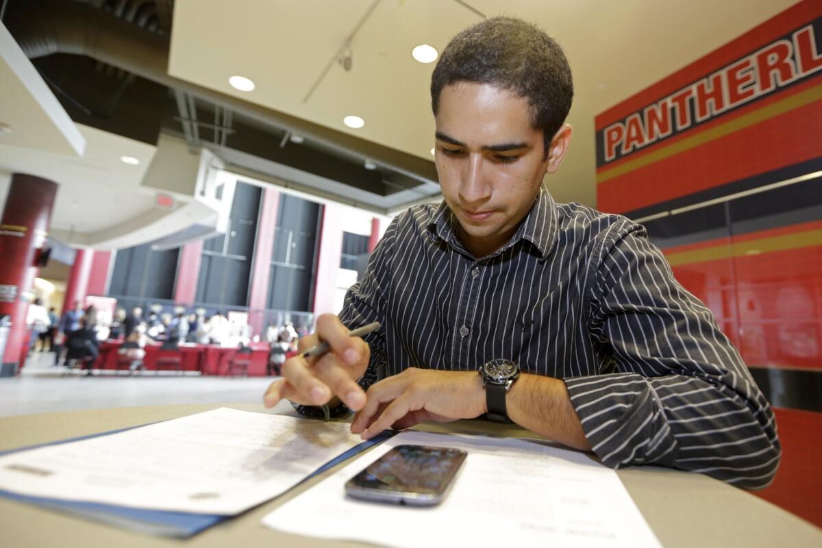 Freddy Jerez, of Hollywood, Fla., fills out a job application during a job fair in Sunrise. Fla., on Aug. 18.