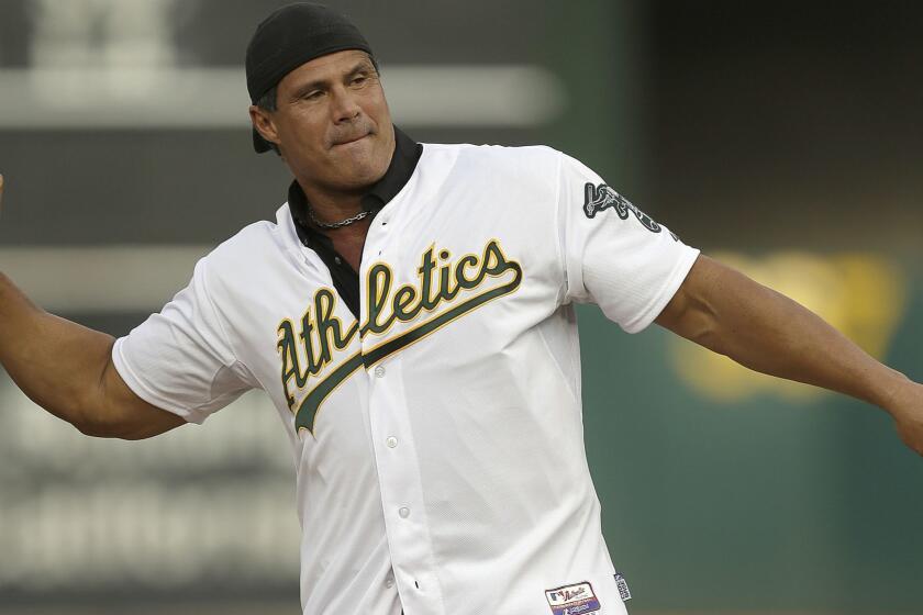 FILE - In this Sept. 3, 2016, file photo, former Oakland Athletics player Jose Canseco throws out the ceremonial first pitch prior to a baseball game against the Boston Red Sox in Oakland, Calif. Canseco, a former major league slugger, has made his pitch for a big job at the White House, tweeting Wednesday, Dec. 12, 2018, to U.S. President Donald Trump: "u need a bash brother for Chief if (sic) Staff." (AP Photo/Ben Margot, File)