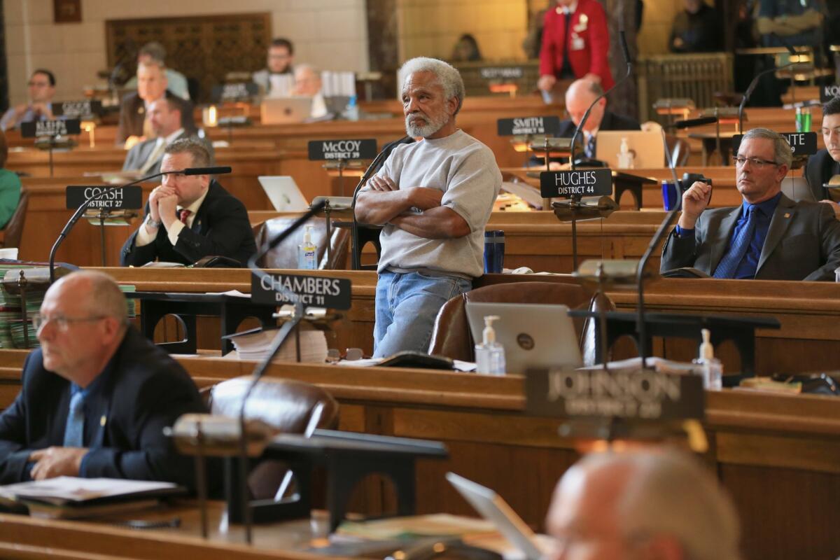 Nebraska state Sen. Ernie Chambers of Omaha, standing center, follows the vote on his bill that seeks to abolish the death penalty, which passed with enough votes to override a promised veto from Gov. Pete Ricketts.