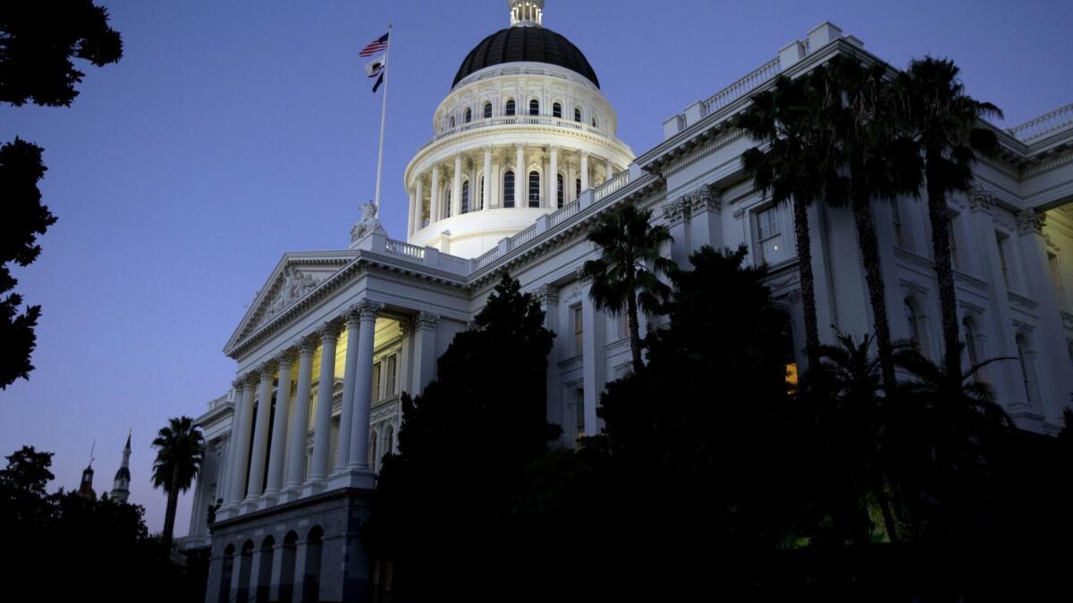 The dome of the state Capitol glows in the early evening in Sacramento. The state panel overseeing campaign finance laws is divided in a power struggle.