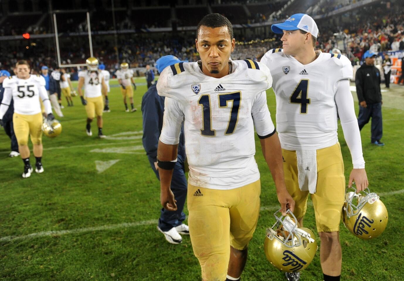 Bruins quarterback Brett Hundley walks off the Stanford Stadium field ahead of reserve quarterback Kevin Prince after a 27-24 loss to the Cardinal on Friday night.