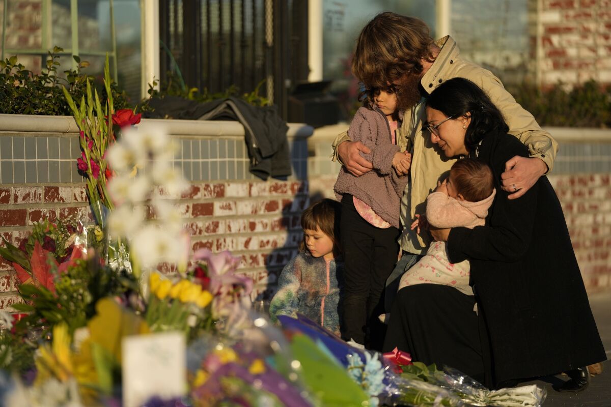FILE - A family gathers at a memorial outside the Star Ballroom Dance Studio, the site of a mass shooting, on Tuesday, Jan. 24, 2023, in Monterey Park, Calif. In the course of 48 hours, two gunmen went on shooting rampages at both ends of California that left 18 dead and 10 wounded. (AP Photo/Ashley Landis, File)
