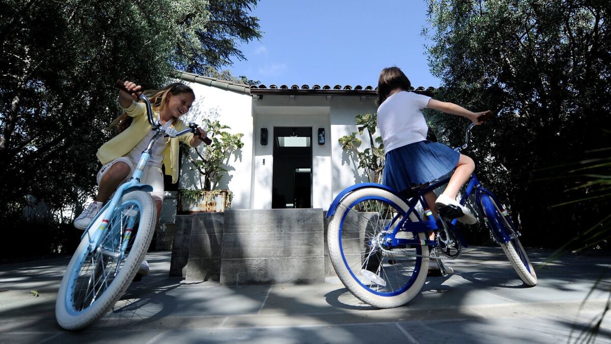 Olive, left, and Ella Collins ride their bikes around the fountain in the front courtyard.