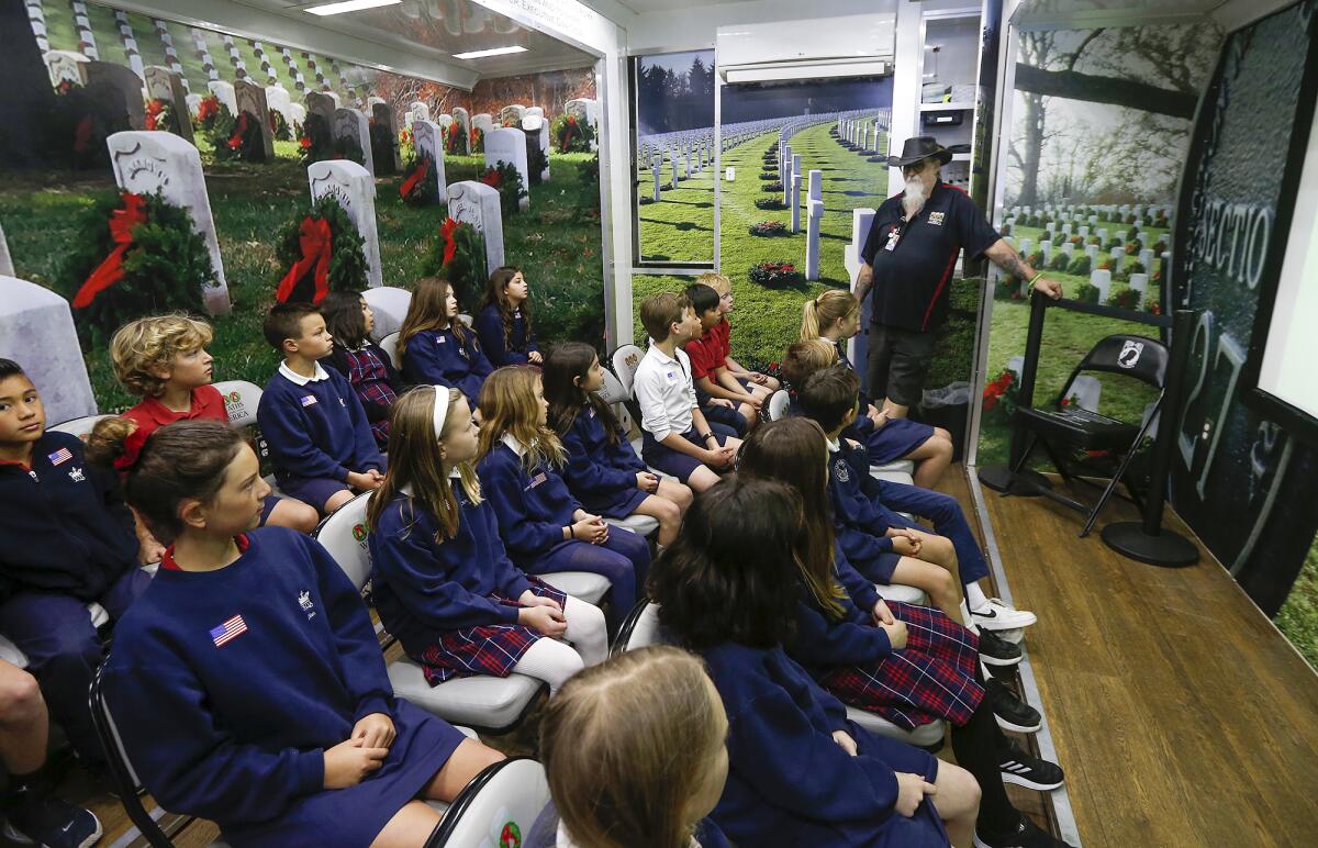 Veteran Delane Kellogg chats with kids at the traveling exhibition Wreaths Across America.