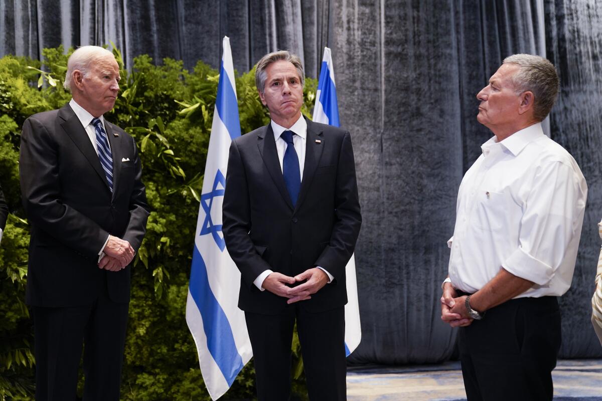 President Biden and Anthony Blinken in front of Israeli flags with a third man.