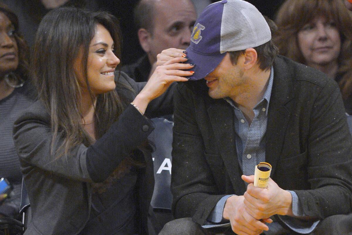 Mila Kunis has a little fun with Ashton Kutcher before an L.A. Lakers game in January.