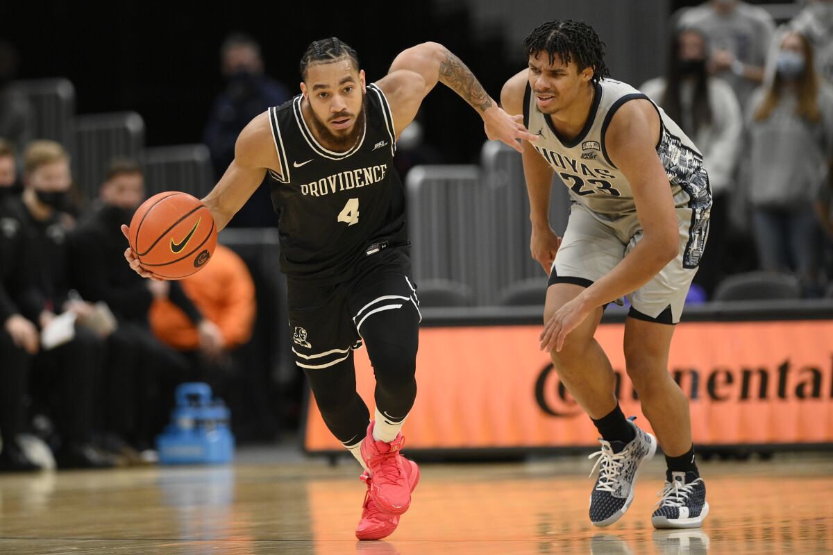 Providence guard Jared Bynum (4) steals the ball away from Georgetown forward Collin Holloway (23) during the first half of an NCAA college basketball game, Sunday, Feb. 6, 2022, in Washington. (AP Photo/Nick Wass)