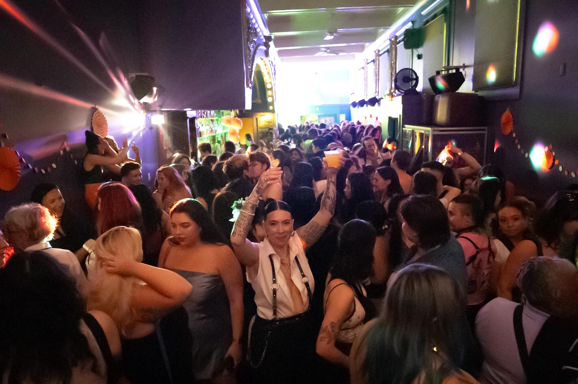 Bartender Amanda Harris cuts through the crowd to deliver a drink during Queer Prom night.