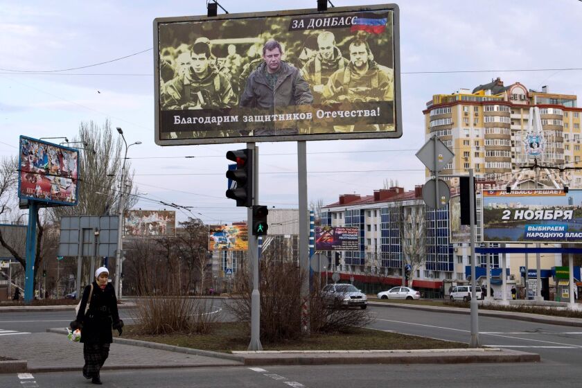 (FILES) This file photo taken on March 18, 2015 shows a woman walking under a billboard featuring a picture of the leader of the self-proclaimed Donetsk People's Republic (DNR) Alexander Zakharchenko (C) and reading: "we are grateful to the defenders of the fatherland" in Donetsk. Russian-backed rebels fighting against Kiev announced on July 18, 2017 the creation of a new "state" that they said would take the place of Ukraine and have its capital in their territory. A constitution presented by rebel leader Alexander Zakharchenko said representatives from the insurgents' self-declared Donetsk and Lugansk "People's Republics" and other regions had agreed to "declare the establishment of a new state, which is the successor of Ukraine." / AFP PHOTO / John MACDOUGALLJOHN MACDOUGALL/AFP/Getty Images ** OUTS - ELSENT, FPG, CM - OUTS * NM, PH, VA if sourced by CT, LA or MoD **