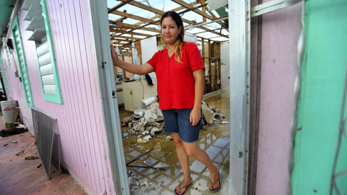 Sandy Nieves stands Friday in the door of her heavily damaged home in the aftermath of Hurricane Maria in Yabucoa, Puerto Rico.