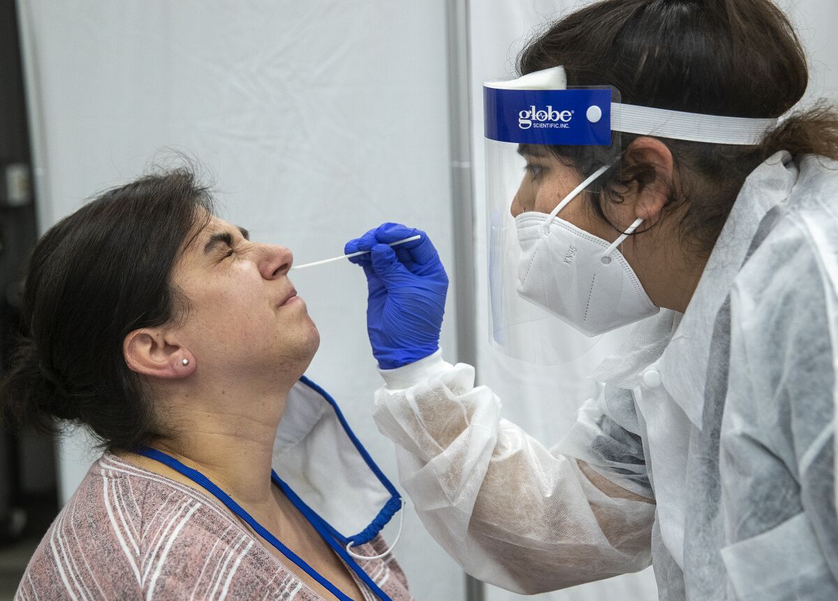 Jessie Sweney endures a nasopharyngeal swab test to see if she has a coronavirus infection.