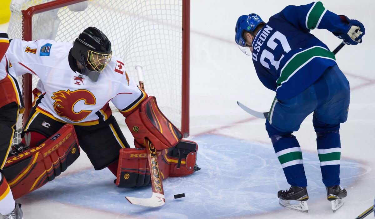Canucks left wing Daniel Sedin is about to score on a rebound after Flames goalie Jonas Hiller blocked a shot in the third period Thursday night in Vancouver.