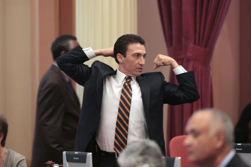 State Sen. Michael J. Rubio (D-Shafter) stretches during a lull in the legislative action at the Capitol last year. He announced his resignation on Friday.