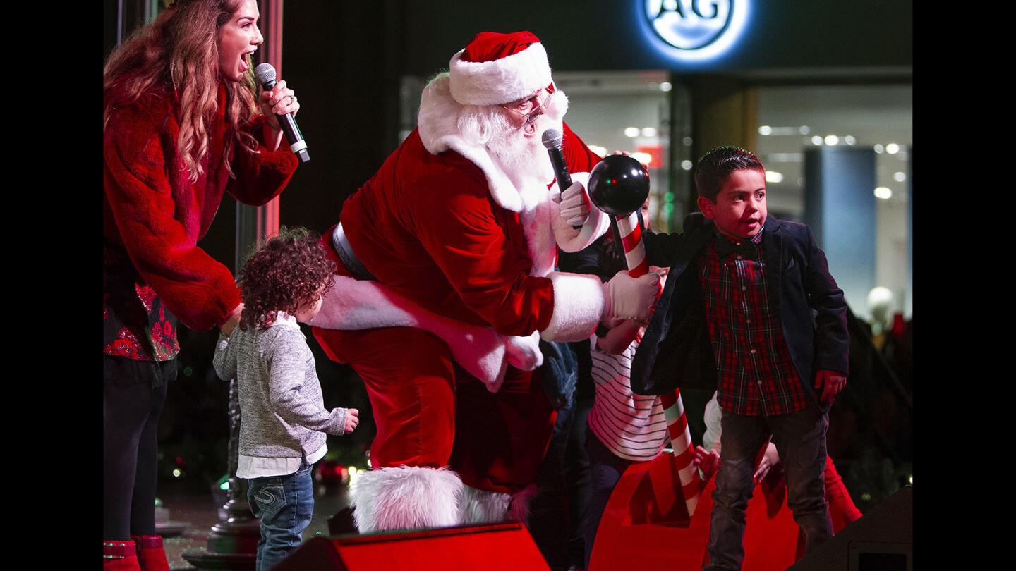 Santa Claus flips on the switch to a 90-foot Christmas tree during the annual tree-lighting ceremony at Fashion Island in Newport Beach on Friday, November 16.