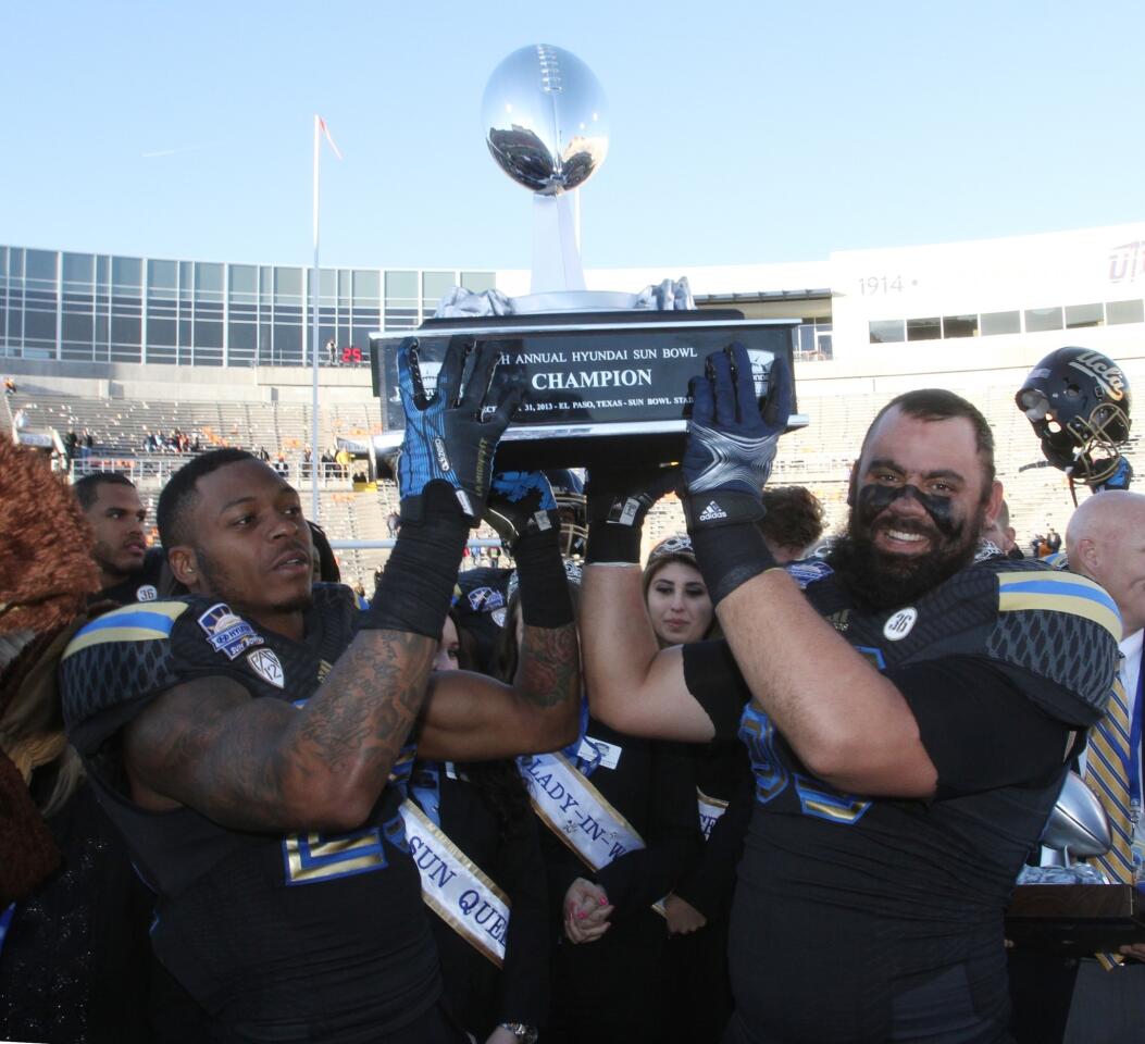 Safety Brandon Sermons, left, and Y back Jordan Barrett raise the Sun Bowl trophy after a 42-12 victory over Virginia Tech on Tuesday in El Paso, Texas.