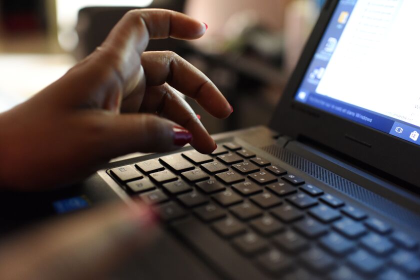 A woman uses a laptop on April 3, 2019, in Abidjan. - According to the figures of the platform of the fight against cybercrime (PLCC) of the national police, nearly one hundred crooks of the internet, were arrested in 2018 in Ivory Coast, a country known for its scammers on the web, has announced on April 2, 2019 the Ivorian authority of regulation of the telephony. (Photo by ISSOUF SANOGO / AFP) (Photo credit should read ISSOUF SANOGO/AFP via Getty Images)