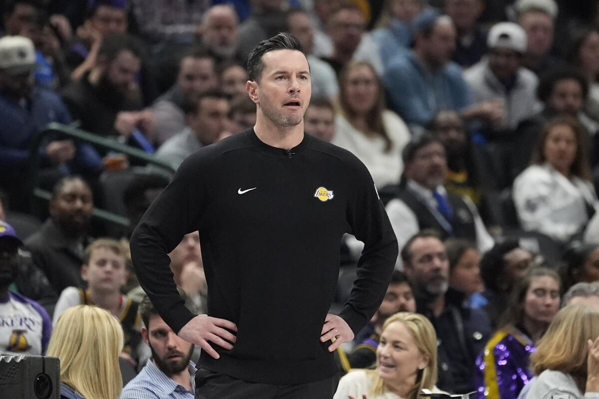 Lakers head coach JJ Redick stands on the sideline with his hands on his hips during a loss to the Mavericks