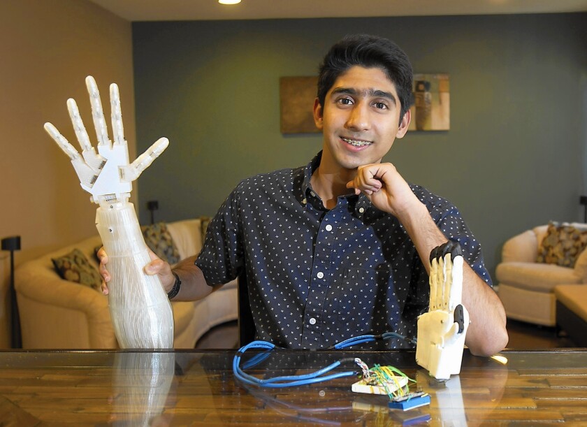 Irvine High School student Nilay Mehta, 17, with an InMoov robotic arm and hand. Nilay programmed the device and entered his project in three sciences fairs this past spring.