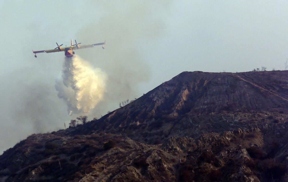 A Super Scooper, on lease from Quebec, makes a water drop on the Madre fire in the Angeles National Forest above Azusa last year. Its lease was extended into March.