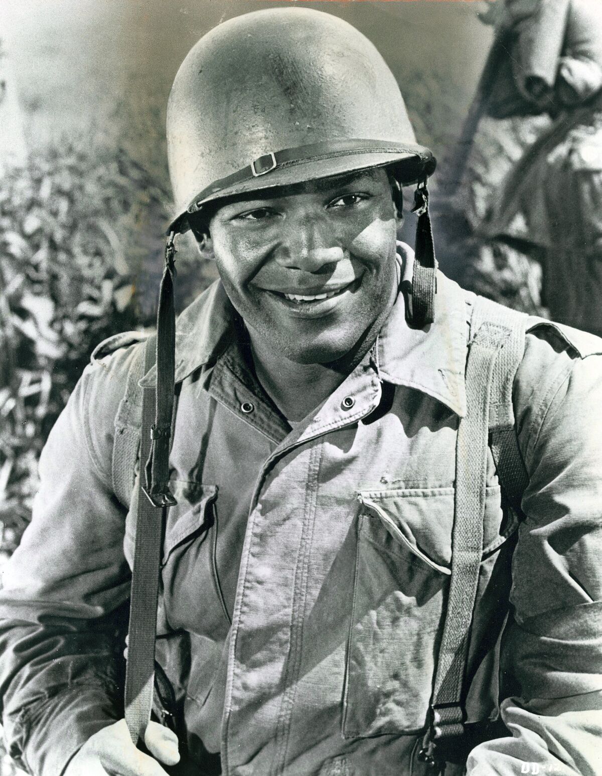 black and white photo of man in uniform and helmet 