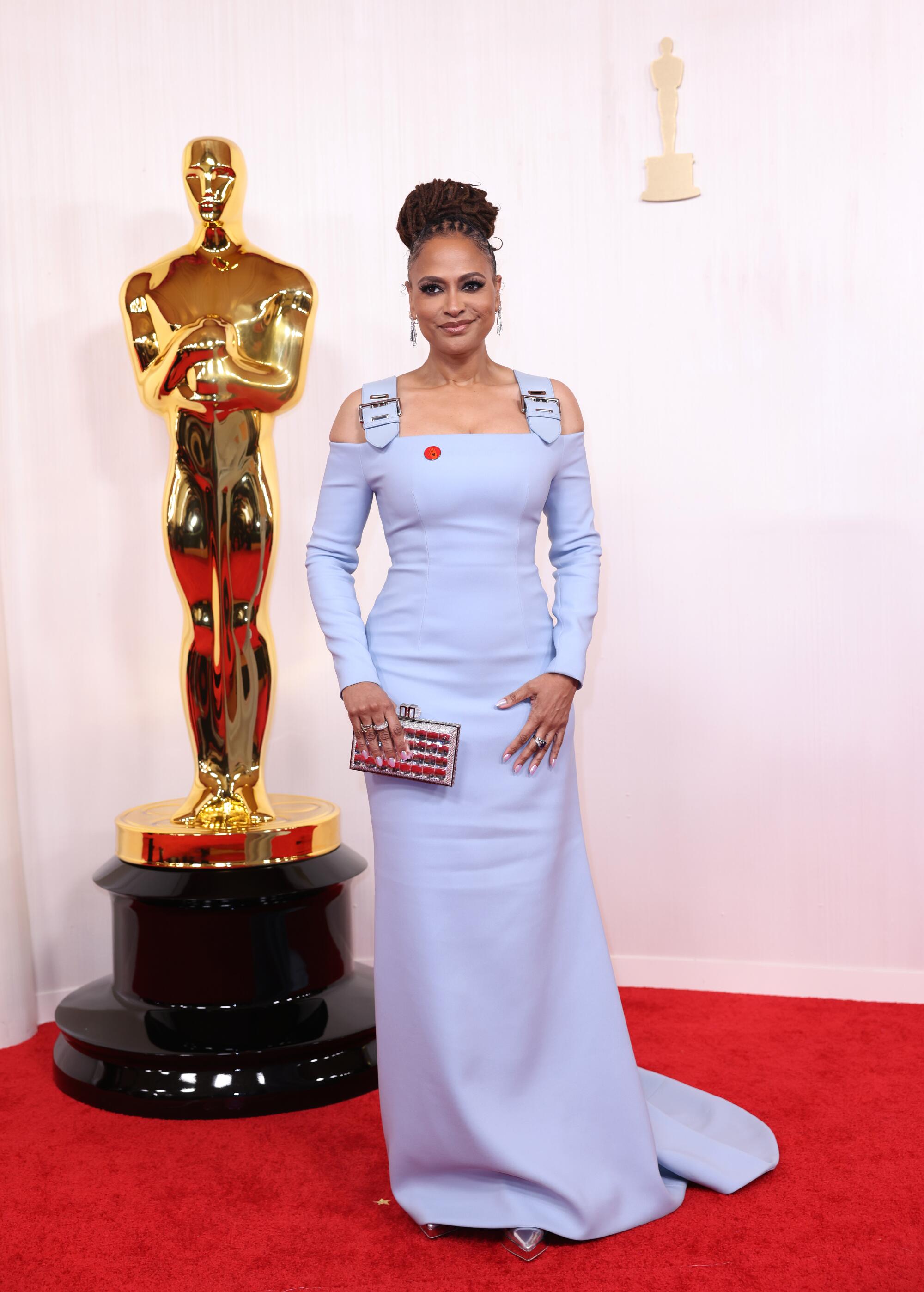 Ava DuVernay wears a pale blue gown with buckles as straps. 