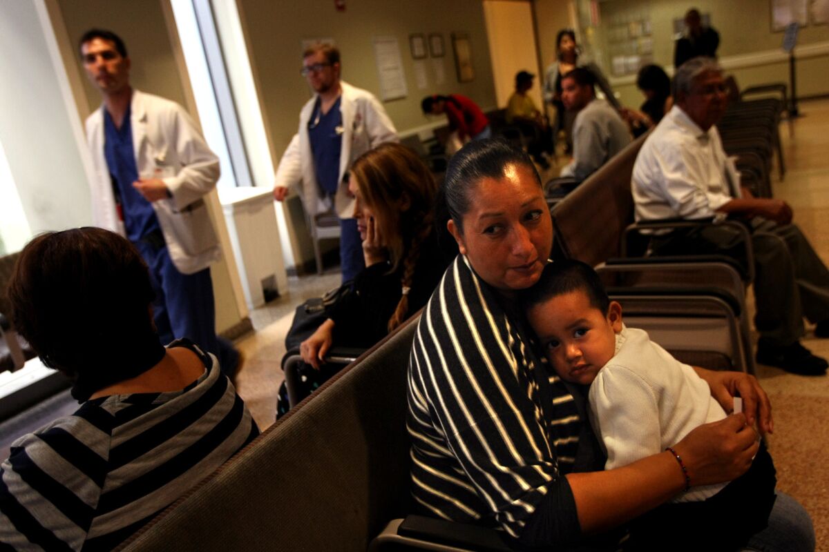 A Medi-Cal patient and her son wait to see a doctor in the emergency ward of L.A. County-USC Medical Center in Los Angeles in 2013. An audit released Tuesday found that California hasn't ensured patients who are part of Medi-Cal have adequate access to doctors.