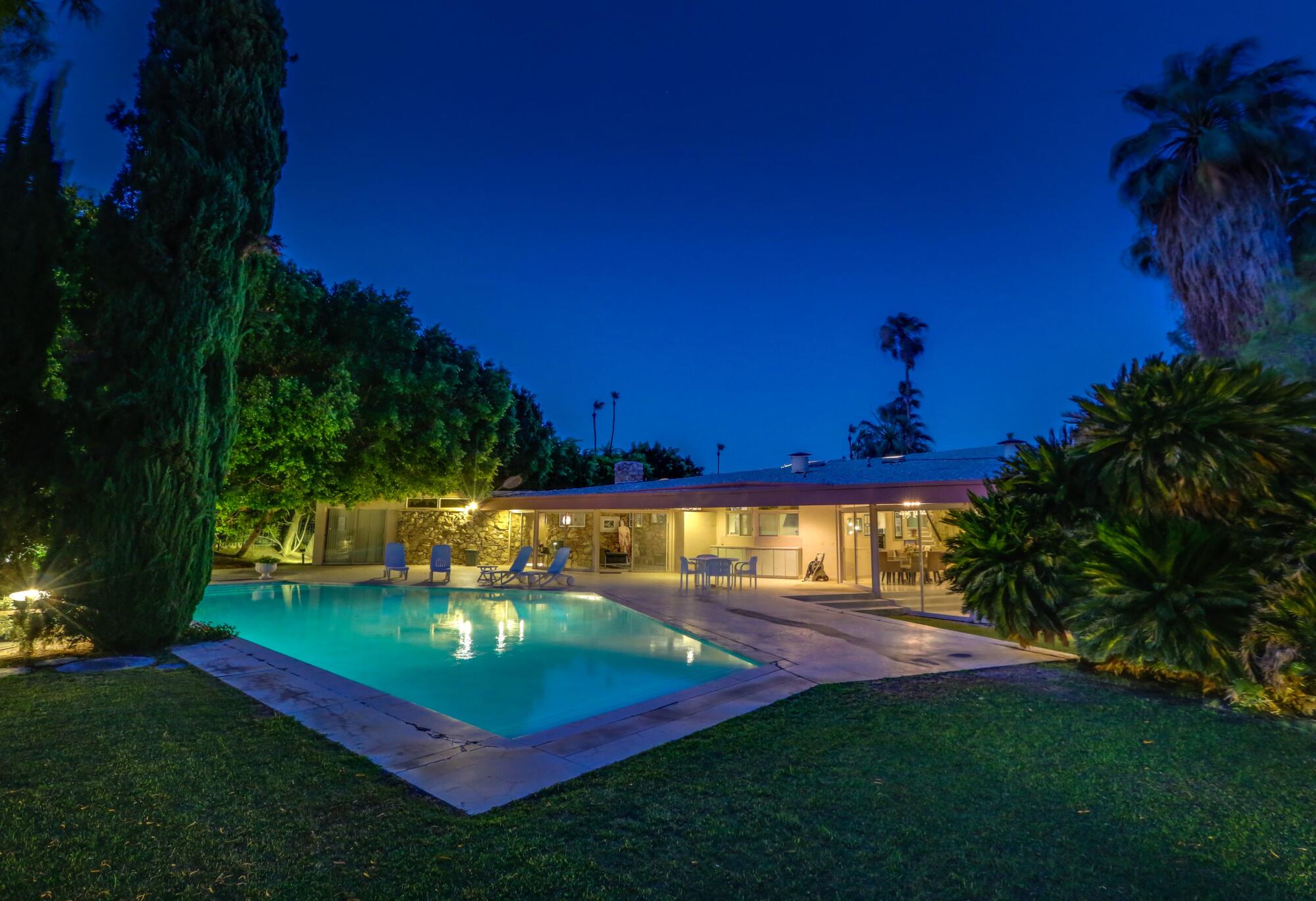 A swimming pool illuminated at night.