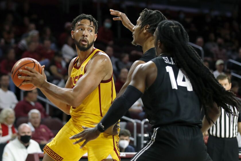 Southern California forward Isaiah Mobley, left, looks to pass the ball against Long Beach State guard Eddie Scott and guard Colin Slater (14) during the first half of an NCAA college basketball game in Los Angeles, Sunday, Dec. 12, 2021. (AP Photo/Alex Gallardo)