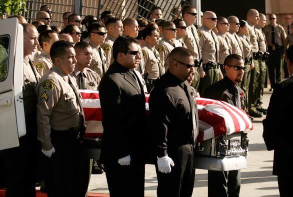 The casket of Los Angeles County Sheriff's Deputy Juan Abel Escalante is removed from the hearse for funeral services at the Cathedral of Our Lady of the Angels in Los Angeles. Escalante, who was assigned to the county's Men's Central Jail in downtown and guarded some of the region's most dangerous inmates, was not wearing a uniform but was on his way to work when he was shot and killed.