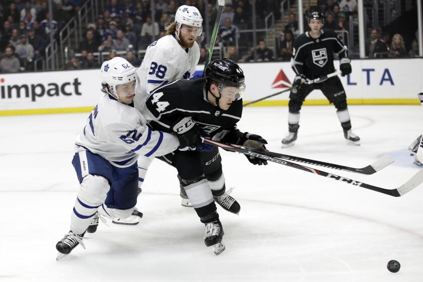 Los Angeles Kings' Mikey Anderson (44) is defended by Toronto Maple Leafs' Denis Malgin during the third period of an NHL hockey game Thursday, March 5, 2020, in Los Angeles. (AP Photo/Marcio Jose Sanchez)