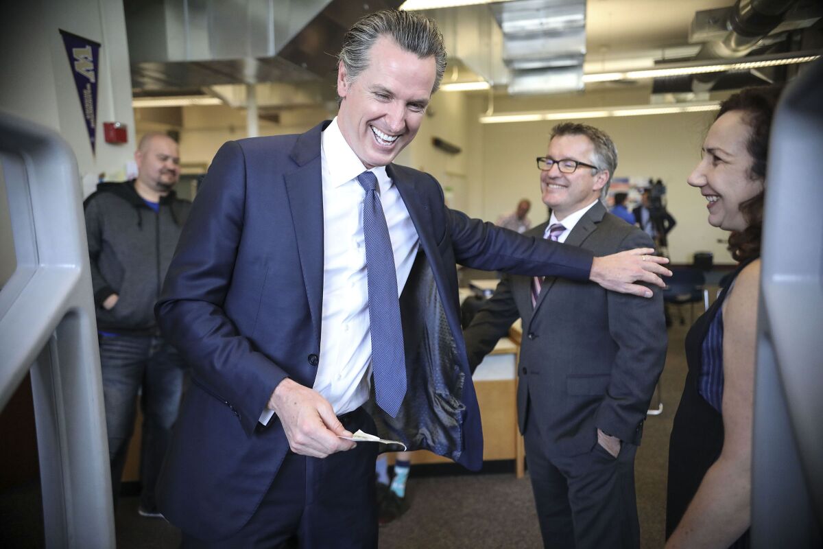 Gov. Gavin Newsom shares a moment with Principal Scott Irwin after a tour of Dana Middle School in Point Loma on Feb. 28. 