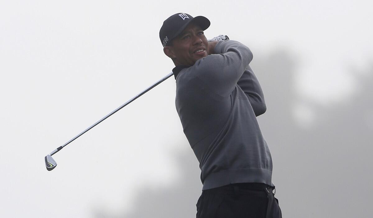 Tiger Woods hits his second shot on the first hole of the North Course during the Farmers Insurance Open Pro Am at Torrey Pines Golf Course on Wednesday.