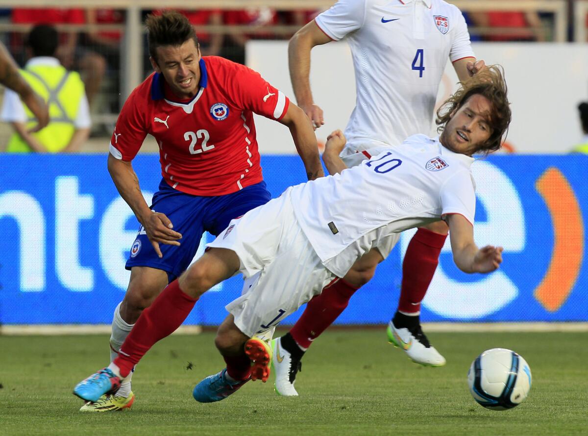 Mix Diskerud (10) of the United States tumbles while fighting for the ball with Chile's Roberto Gutierrez during a friendly soccer match in Rancagua on Jan. 28.