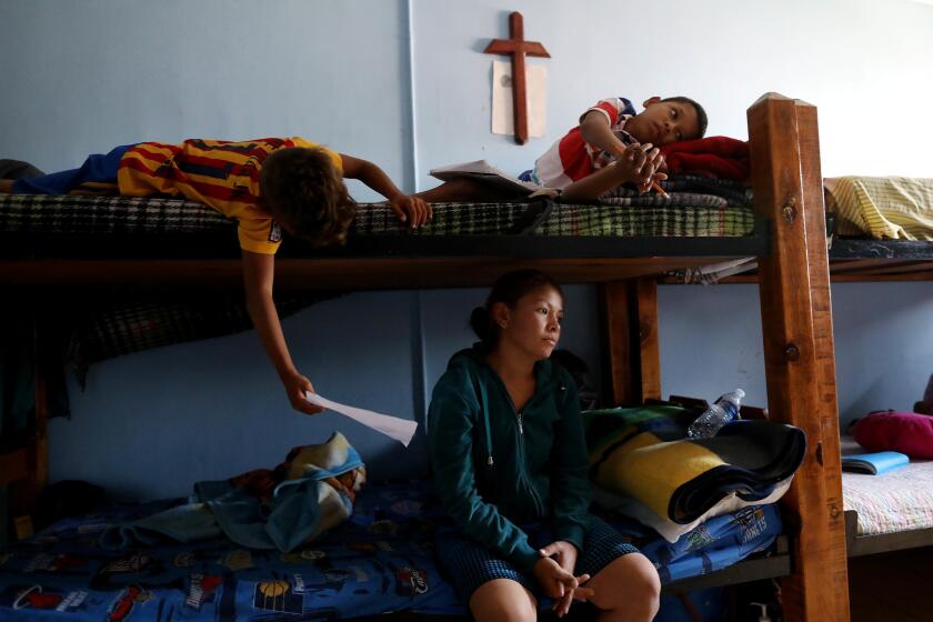 CIUDAD JUAREZ, CHIHUAHUA -- THURSDAY, MARCH 28, 2019: Merlin Genoveva Avila Amador, 27, of Tegucigalpa, Honduras, with children Leonel Moya Avila, 8, left, and Jonathan Moya Avila, 11, at the Casa Del Migrant shelter in Ciudad Juarez, Chihuahua, on March 28, 2019. Amador has been living 28 days in the shelter awaiting her number to be called to present herself and two children to U.S. Border Patrol to seek asylum in the United States. Genoveva's husband was kidnapped and killed Nov. 2016. (Gary Coronado / Los Angeles Times)