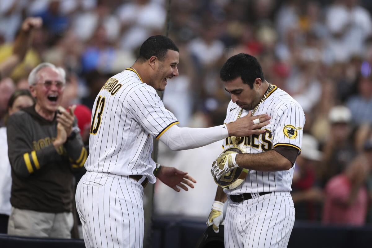 San Diego Padres' Daniel Camarena, right, is congratulated by Manny Machado after hitting a grand slam off Washington Nationals starting pitcher Max Scherzer during the fourth inning of a baseball game Thursday, July 8, 2021, in San Diego. (AP Photo/Derrick Tuskan)