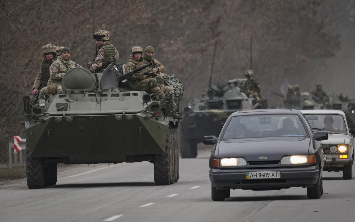 Ukrainian servicemen sit atop armored personnel carriers  in their country 
