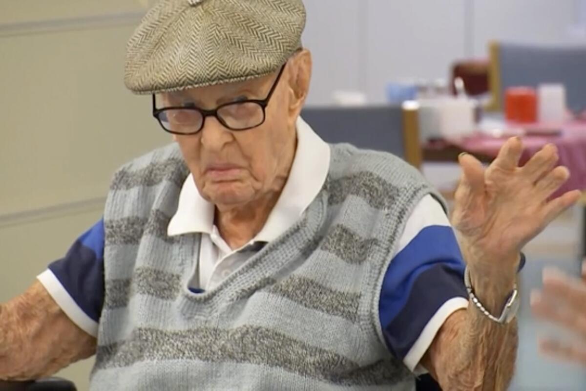 In this image made from video, Australia's Dexter Kruger gestures at a nursing home in the rural Queensland state town of Roma, Australia on May 13, 2021. Kruger, Australia’s oldest-ever man, has included eating chicken brains among his secrets to living more than 111 years. The retired cattle rancher on Monday, May 17, 2021, marked 124 days since he turned 111, a day older than World War I veteran Jack Lockett was when he died in 2002. (Australian Broadcasting Corporation via AP)
