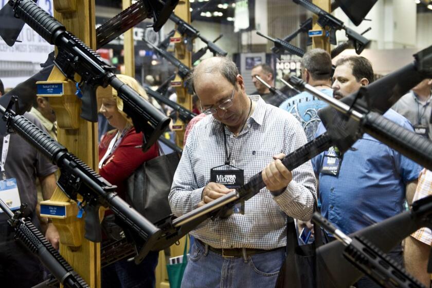 ORG XMIT: 486942421 A convention goer examines weapons in the exhibit hall at the143rd NRA Annual Meetings and Exhibits at the Indiana Convention Center in Indianapolis, Indiana, on April 26, 2014. AFP PHOTO / Karen BLEIERKAREN BLEIER/AFP/Getty Images ** OUTS - ELSENT and FPG - OUTS * NM, PH, VA if sourced by CT, LA or MoD ** ORG XMIT: CHI1404261411487477