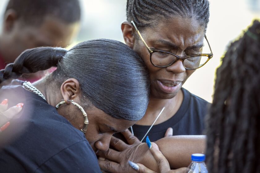 Tmika Wilkerson, left, and Kimberly Wilkerson pray as mourners gather for a remembrance service at Immerse Church of Ocala for Ajike Owens, Thursday, June 8, 2023, in Ocala, Fla. Owens was fatally shot by her neighbor Susan Lorincz when she went to Lorincz's door. Lorincz was arrested and charged in the shooting. (AP Photo/Alan Youngblood)