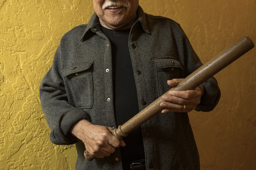 SAN JUAN BAUTISTA, CA - APRIL 6, 2022: Playwright Luis Valdez holds a police baton, used in the 1943 Zoot Suit riots, at El Teatro Campesino in San Juan Bautista, Calif., Thursday, April 6, 2023. (Nic Coury / For The Times)