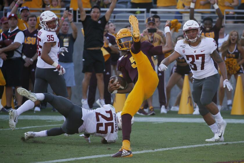 Arizona State quarterback Jayden Daniels, front center, flips into the end zone for a touchdown as he gets past Washington State cornerback Armani Marsh (35), safety Skyler Thomas (25) and linebacker Justus Rogers (37) during the second half of an NCAA college football game Saturday, Oct. 12, 2019, in Tempe, Ariz. (AP Photo/Ross D. Franklin)