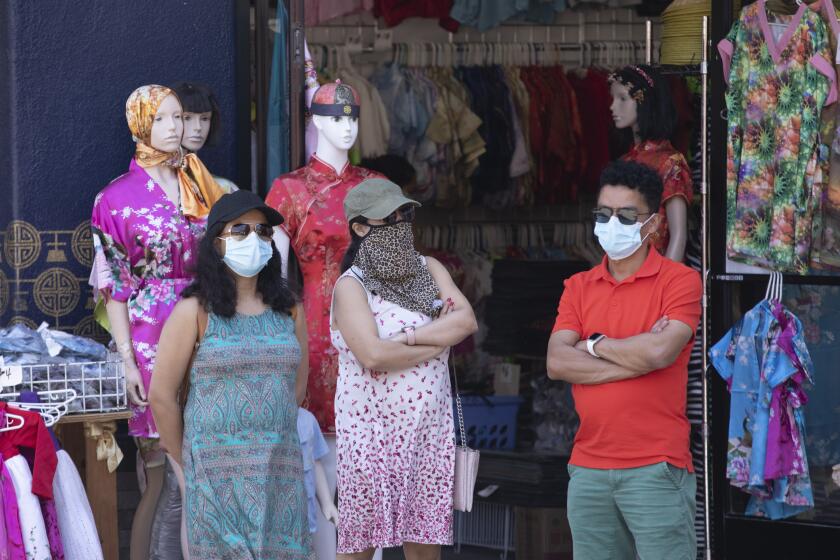 LOS ANGELES, CA - JULY 17: Visitors to Chinatown wear masks even when outdoors. The LA County mask mandate will go into effect at 11:59 p.m. Saturday, July 17, 2021 requiring masks be worn indoors with the exception that masks can be removed if dining in a restaurant. Photographed in Chinatown on Saturday, July 17, 2021 in Los Angeles, CA. (Myung J. Chun / Los Angeles Times)