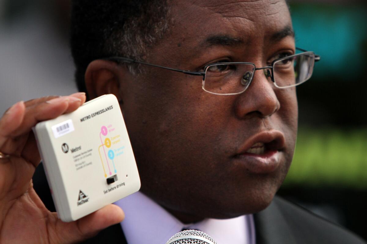 Los Angeles County Supervisor Mark Ridley-Thomas shows a FasTrak device in 2012.
