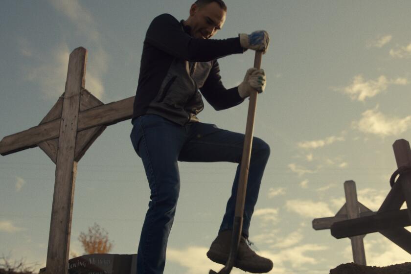 A man digs a grave for community member.