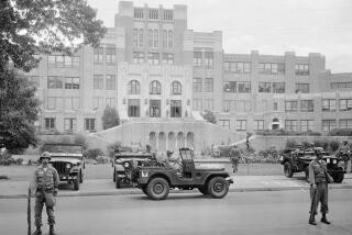 FILE - Members of the 101st Airborne Division take up positions outside Central High School in Little Rock, Ark., Sept. 26, 1957. The troops were on duty to enforce integration at the school. On Monday, March 25, 2024, a teacher and two students from the school sued Arkansas over the state's ban on critical race theory and “indoctrination” in public schools, asking a federal judge to strike down the restrictions as unconstitutional. (AP Photo/File)