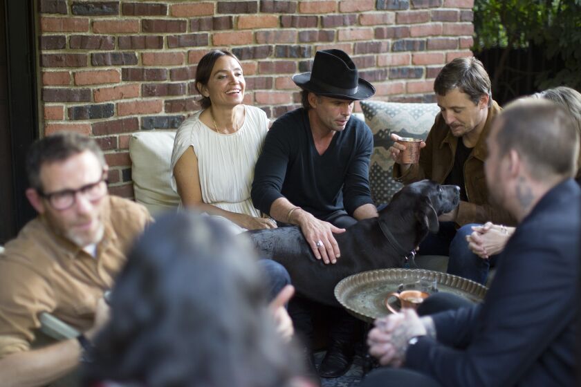 Actor Walton Goggins and wife Nadia Conners, left, entertain guests, including singer-songwriter Sturgill Simpson, right, at their Hollywood home.
